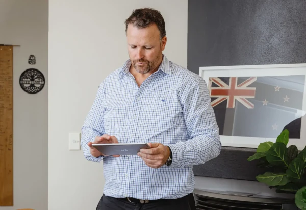 Pukeko rental manager reviewing his tablet